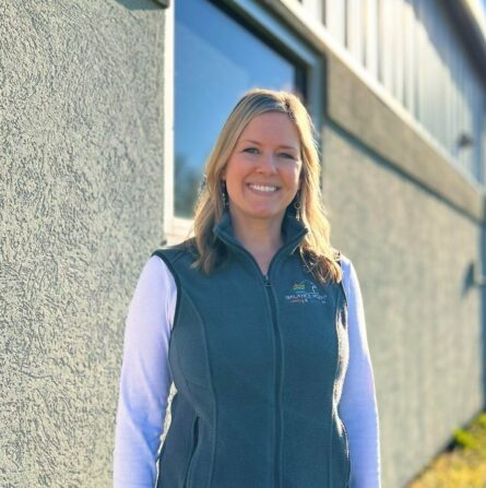 Kate smiling at the camera as she stands in front of a building