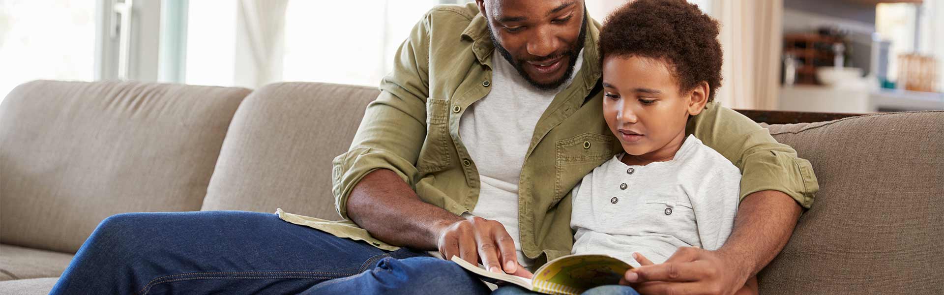 man and child reading indoors