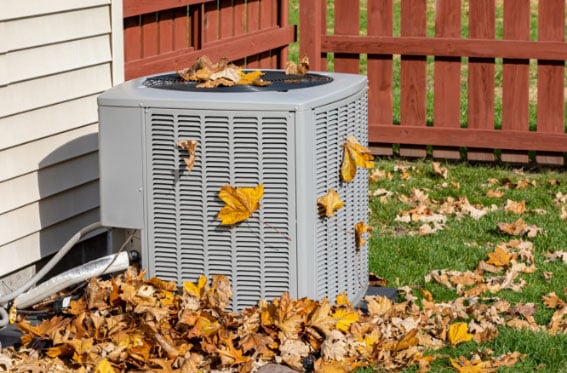 air conditioner surrounded by leaves