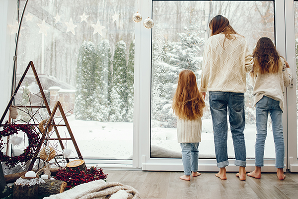 mom and daughters looking out at the snow